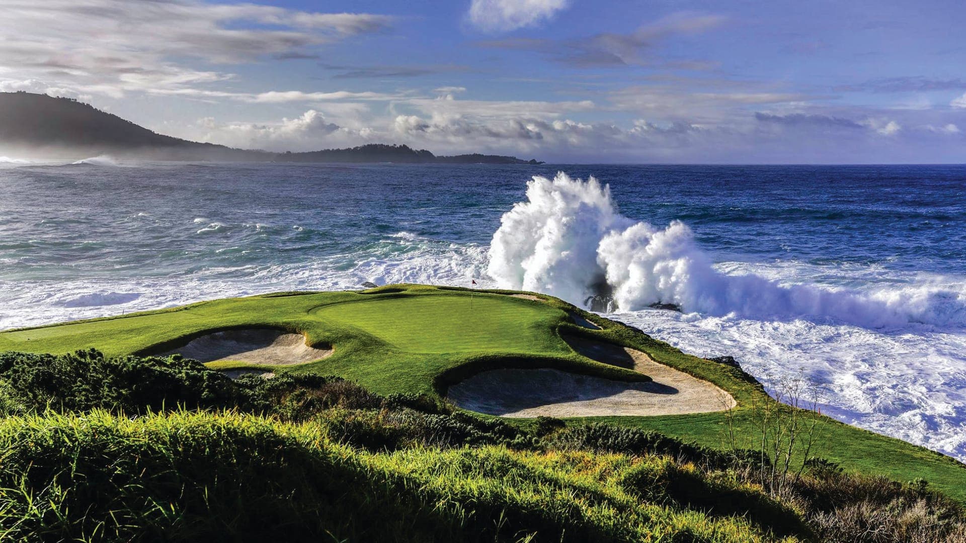 The 7th hole at Pebble Beach Golf Links — the iconic clifftop par-3 over crashing Pacific surf on the Monterey Peninsula