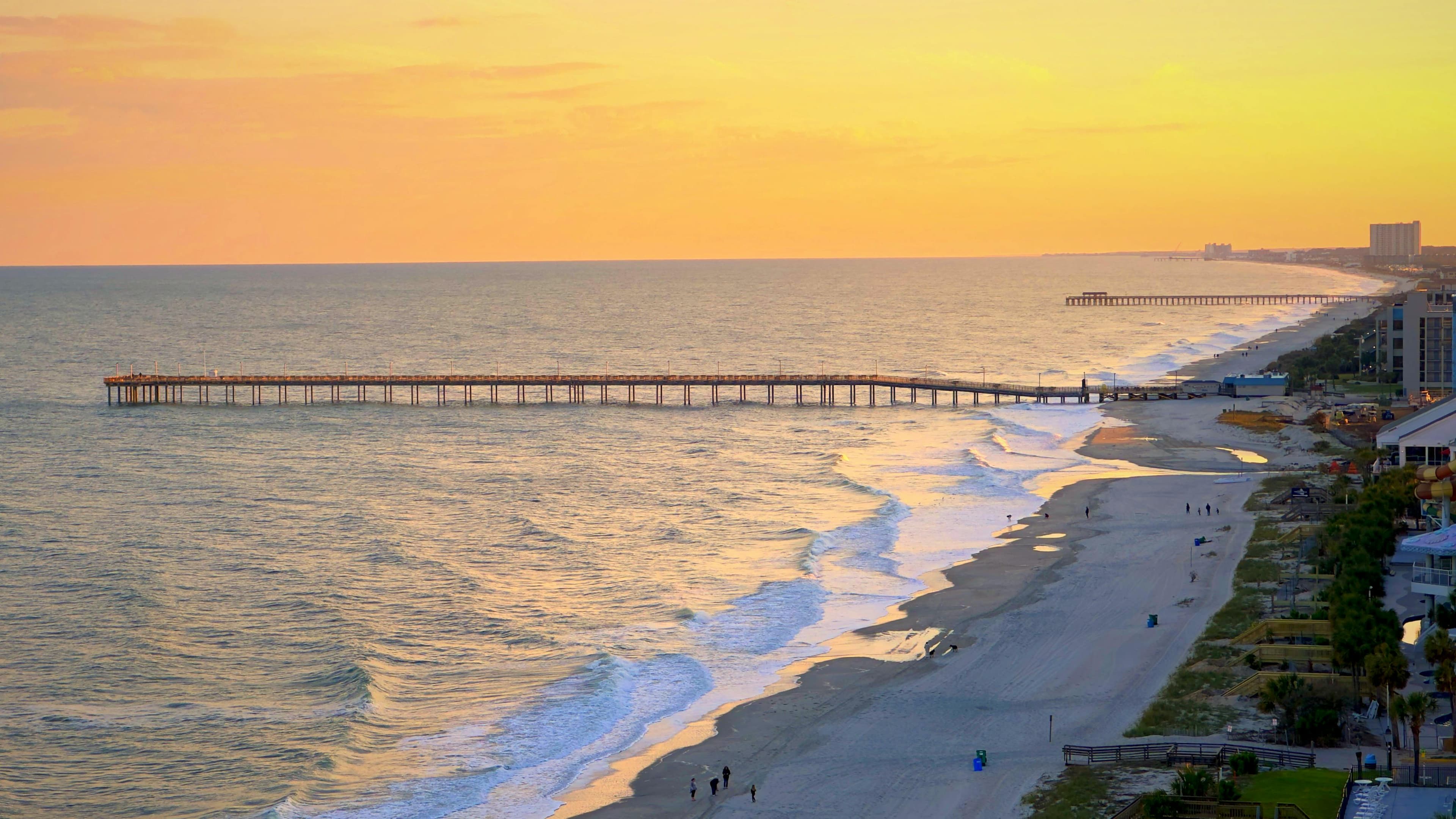 Aerial view of Myrtle Beach shoreline and fishing pier at golden hour