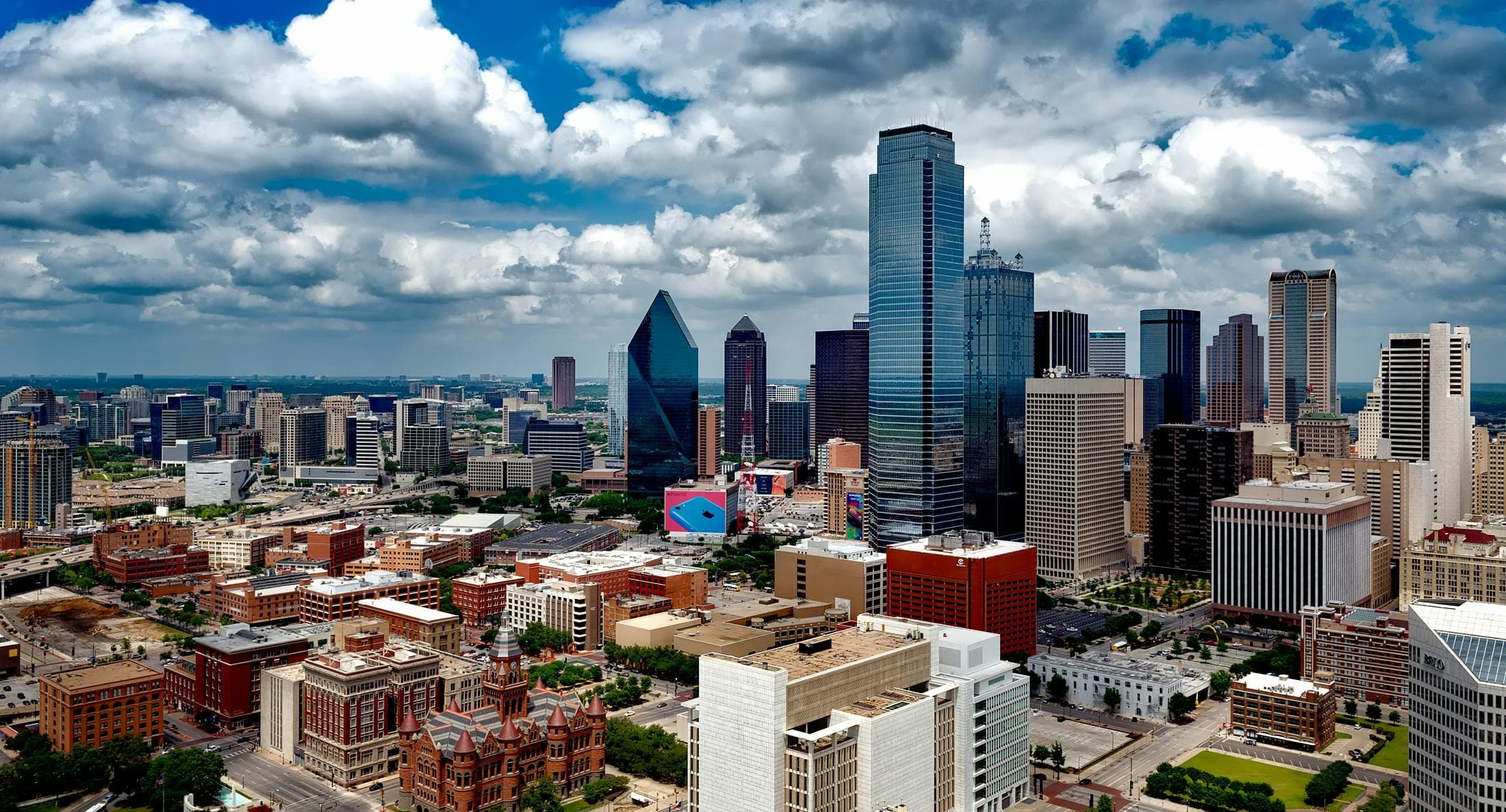 Aerial view of the Dallas-Fort Worth skyline under cumulus clouds